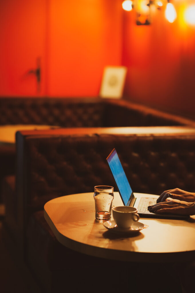 Une cliente en train de boire un cafÃ© bio avec son ordinateur